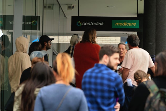 People are seen lining up at Centrelink in Bondi Junction on March 23, 2020 in Sydney, Australia. From midday Monday, venues such as bars, clubs, nightclubs, cinemas, gyms and restaurants, along with anywhere people remain static would be closed.