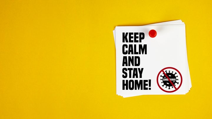 Keep Calm And Stay Home motivation letter written on post-it paper against Coronavirus