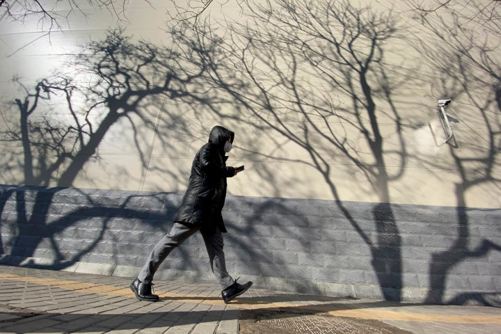 A resident walking in Beijing on Tuesday, March 3, 2020. China's efforts to control the spread of the new coronavirus have shuttered factories, emptied airports and resulted in a steep drop in carbon emissions and other pollutants. However, analysts caution that the dip in pollution is likely temporary. 