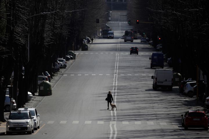 A woman walks her dog in the EUR neighbourhood in Rome, Monday, March 23, 2020.