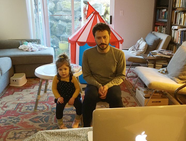 Kate Brumage's husband and daughter, Helen, video chat with family members. A tent has been set up in their living room for her daughter to play in.