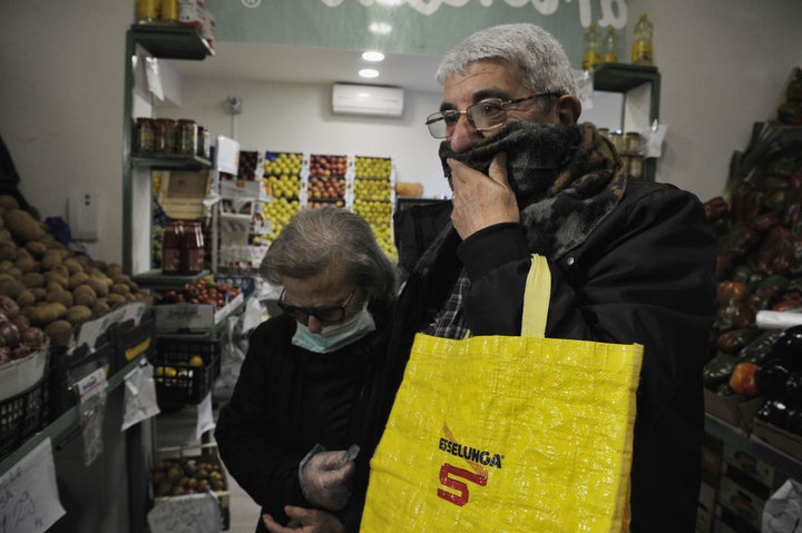 Un hombre se tapa la boca con una bufanda en un supermercado italiano.