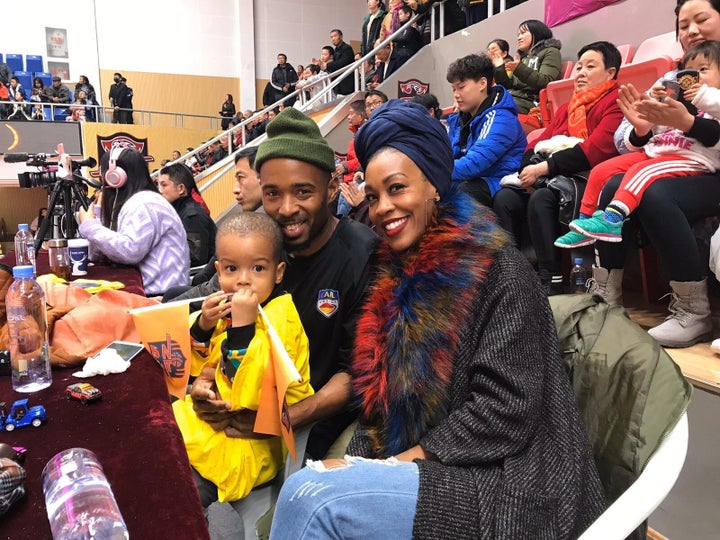 Imani Basheer attends a football game in Wuhan, China, with her husband and son. The family was forced to sell their belongin