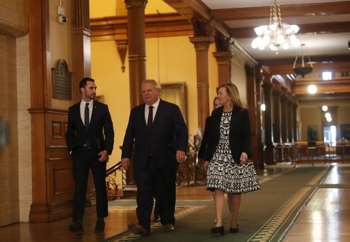 Ontario Premier Doug Ford walks through Queen's Park with cabinet ministers before an announcement on March 20, 2020.