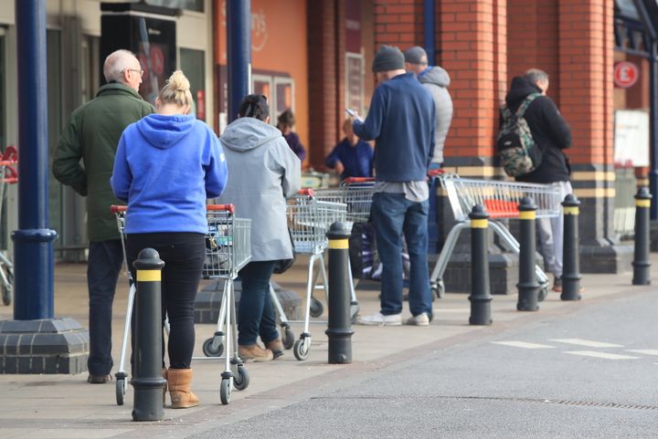 People queue at a Sainsbury's supermarket at Colton, on the outskirts of Leeds, the day after prime minister Boris Johnson put the UK in lockdown to help curb the spread of the coronavirus.