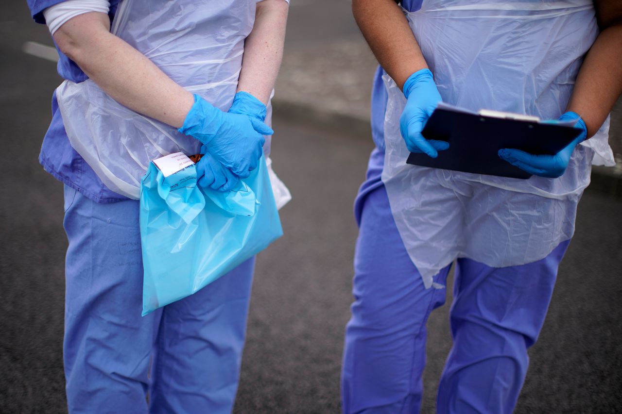 An NHS nurse holds a coronavirus testing kit at a drive through coronavirus testing site in Wolverhampton