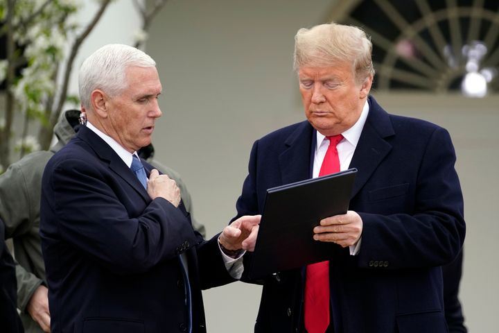 President Donald Trump speaks with Vice President Mike Pence as they arrive for a Fox News Channel virtual town hall, at the White House, Tuesday, March 24, 2020, in Washington. (AP Photo/Evan Vucci)
