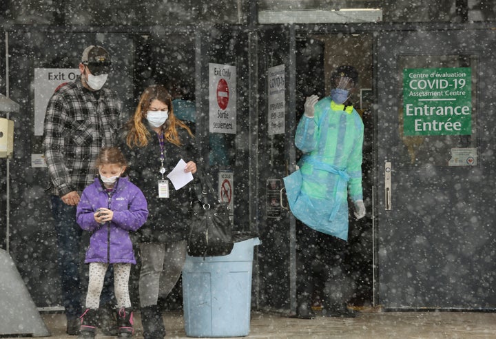 An Ottawa Public Health officer waves to the next person in line at a COVID-19 testing centre on March 23, 2020 in Ottawa. 