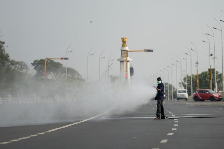 A health worker sprays disinfectant on a deserted road during the one-day Janata (civil) curfew imposed by the government, in Chennai, on March 22, 2020.