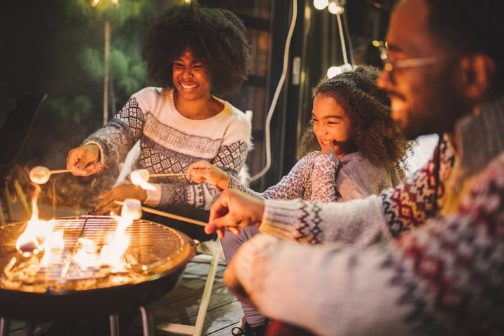 Family on porch making roasted marshmallow