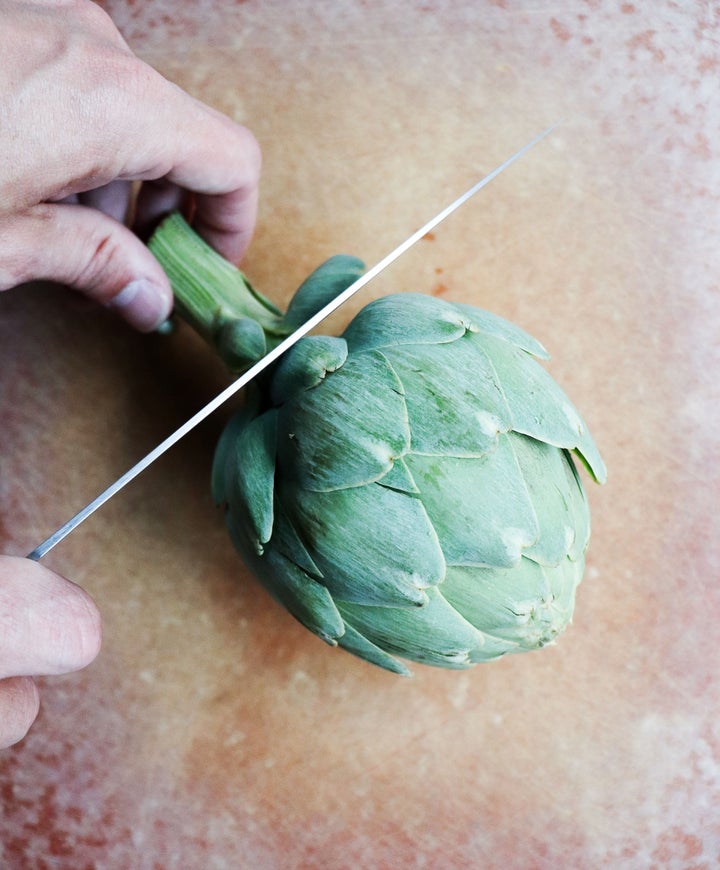 Cut stem off bottom of artichoke, then cut about 1/2 inch off the top artichoke.