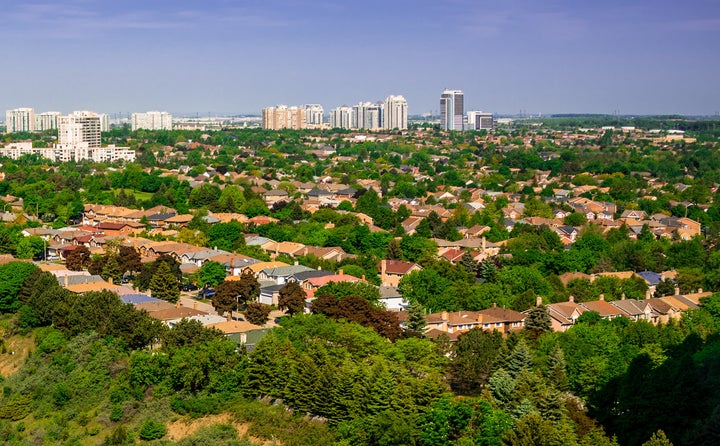 This undated file photo shows an aerial view of suburban homes in Toronto, with high-rise apartments in the distance. Households and businesses across Ontario may get an extra three months to pay their next property tax bills.