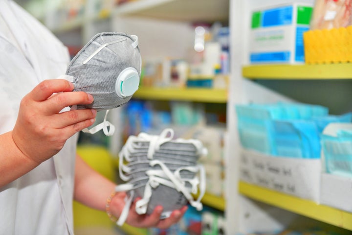 A pharmacist holds an N95 mask.