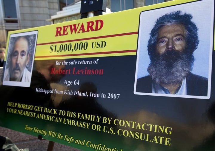 In this March 6, 2012 file photo, an FBI poster shows a composite image of former FBI agent Robert Levinson, right, and a sho