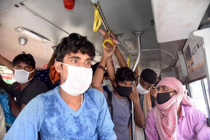People arriving from different states board a bus at Dak Bungalow crossing during the second day of lockdown imposed by the state government to curb the spread of coronavirus, on March 24, 2020 in Patna, India.