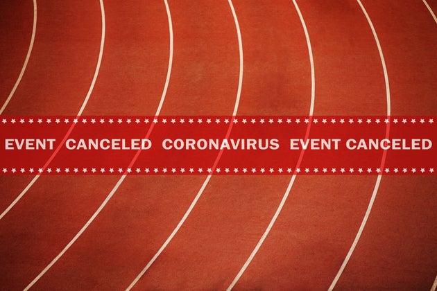 warning tape event canceled coronavirus in background running athletics red track