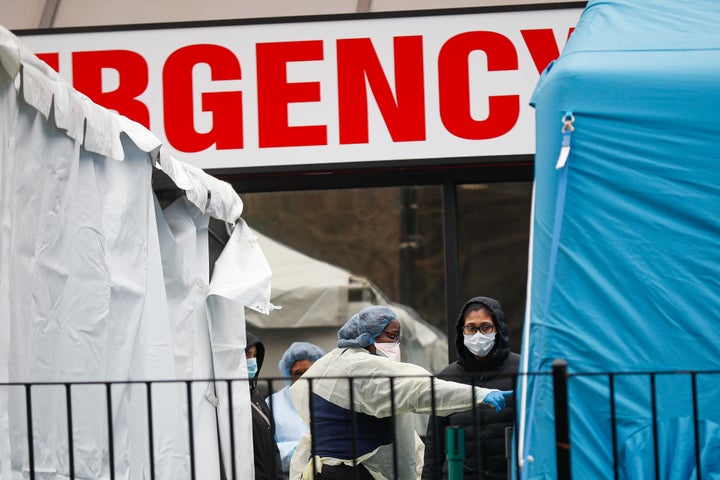 A medical worker directs a patient to enter a COVID-19 testing site at Elmhurst Hospital Center.