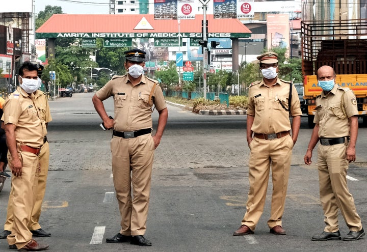 Police stand guard on a road in Kochi, Kerala, on March 25, 2020.