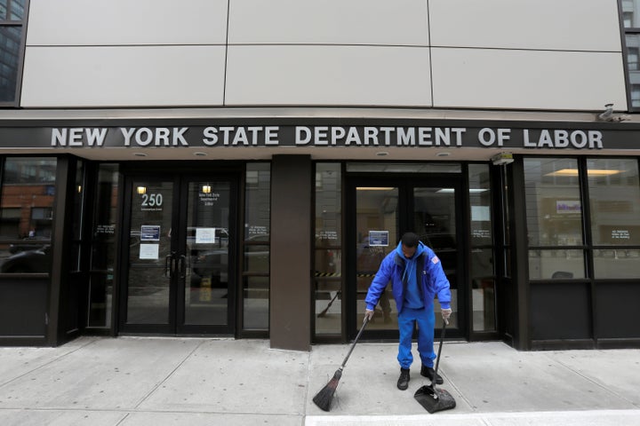 A person sweeps outside the entrance of the New York State Department of Labor offices, which closed to the public due to the