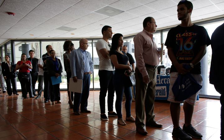 In this file photo, a group of people line up for unemployment benefits in a government office in Miami Lakes, Fla., July 19, 2016. Canada's unemployment rate is likely to hit a 70-year high amid the COVID-19 crisis, a new analysis says.
