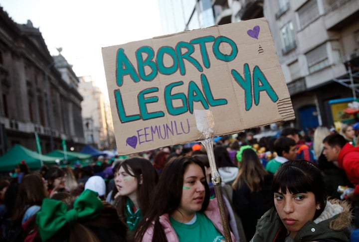 A pro-choice activist holds a sign that reads in Spanish "Legal abortion now" during a rally to legalize abortion outside Con