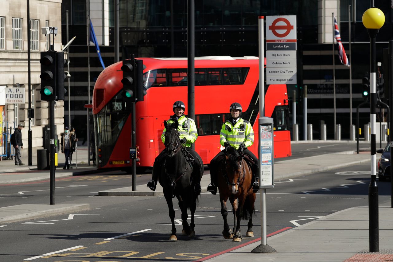 Two mounted police make their way over Westminster Bridge in London