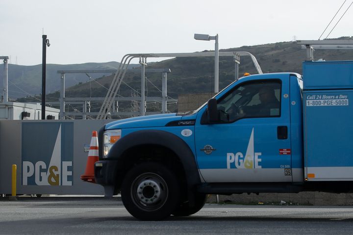 A Pacific Gas and Electric truck drives past a PG&E location in San Francisco. The utility company said it will use money from a wildfire victims' trust to pay a $4 million fine for starting the blazes.