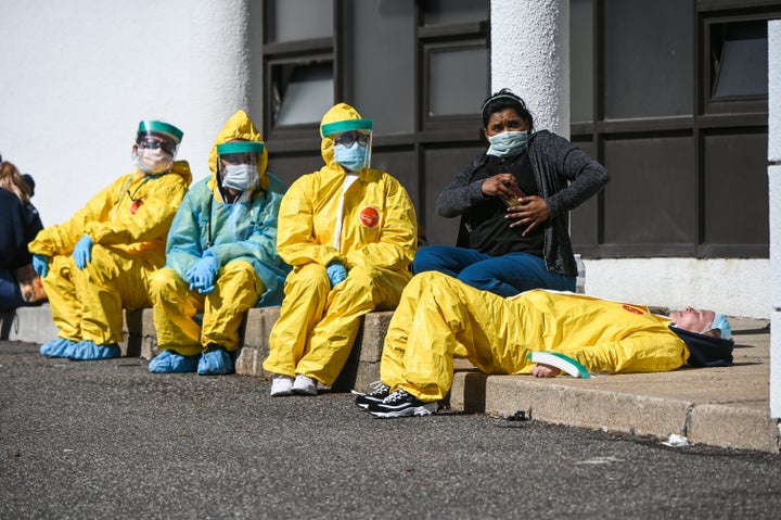 Health care professionals take a break awaiting patients as they test for COVID-19 at a testing site in Jericho, New York.