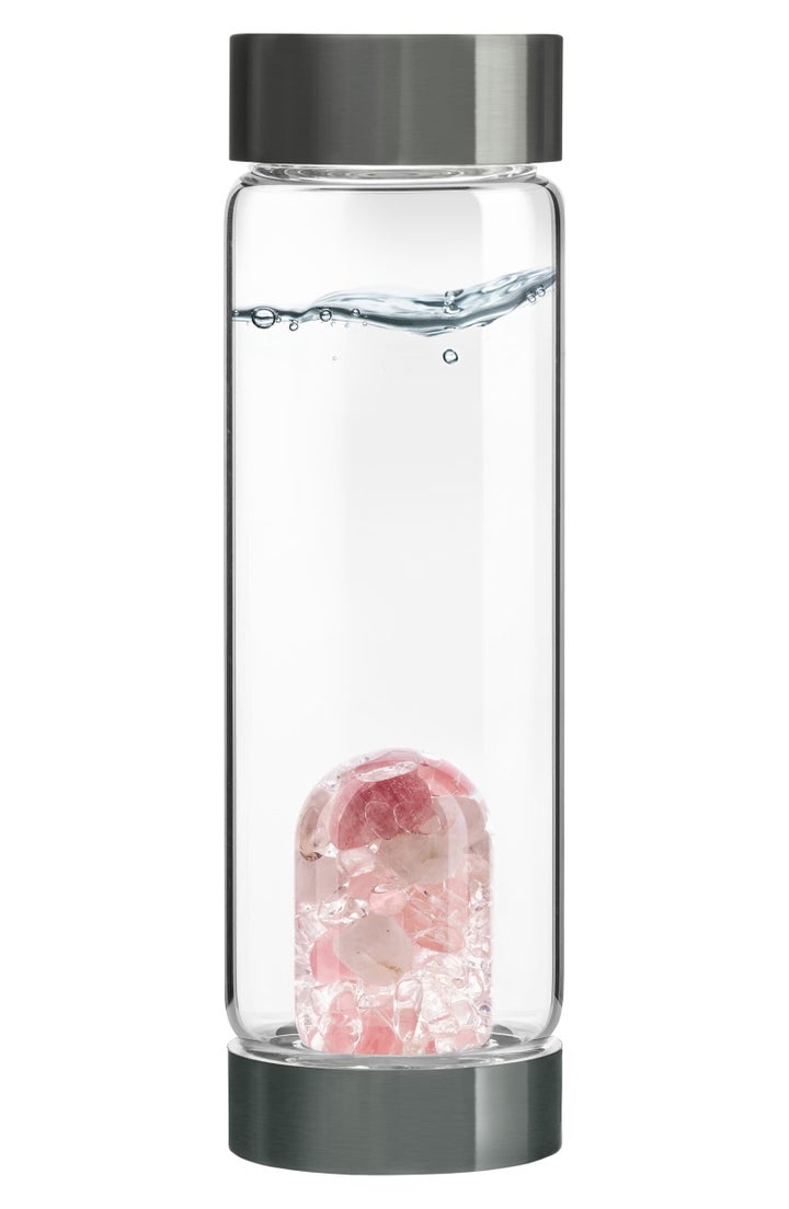 A water bottle made from premium, high-quality glass with an interchangeable gempod base filled with a selection of hand-picked gemstones.