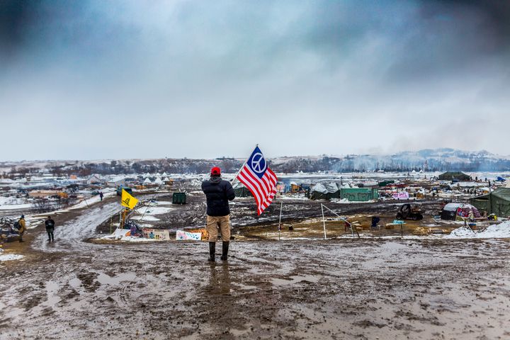 A defiant Dakota Access pipeline protester faces off against militarized police in 2017 as law enforcement raided their camp.