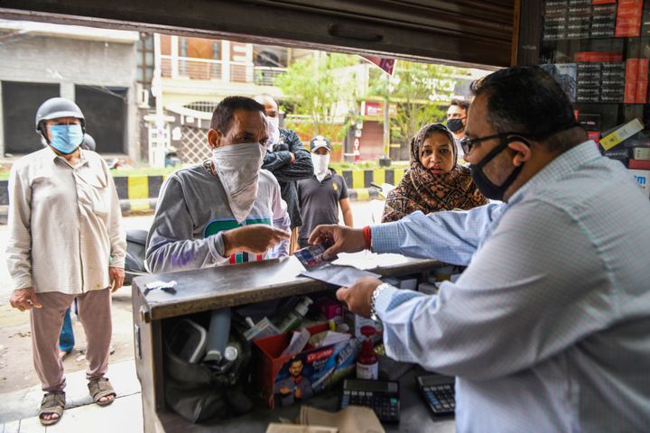 People buy medicine from a pharmacy during a government-imposed nationwide lockdown as a preventive measure against the COVID-19 coronavirus in Amritsar on March 28, 2020.