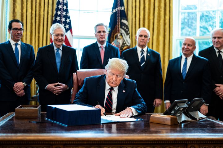 U.S. President Donald Trump signs H.R. 748, the CARES Act in the Oval Office of the White House on March 27, 2020 in Washington, D.C.