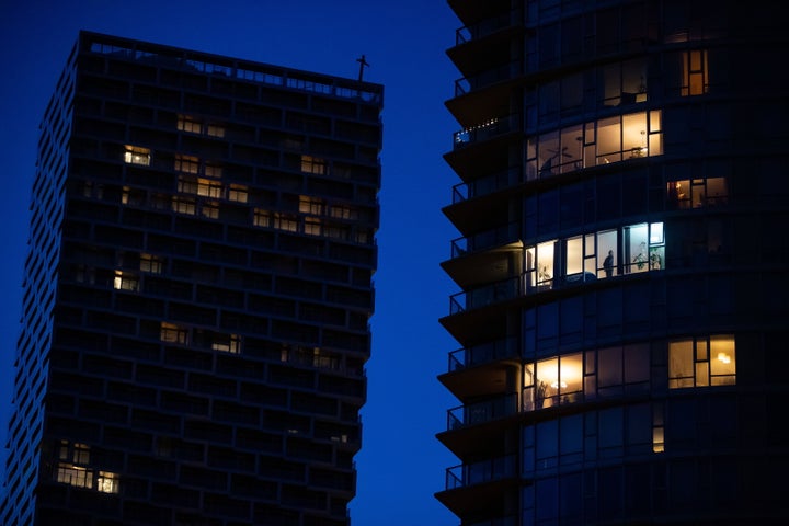 A man stands in the window of an upper floor condo as people have been urged to stay home to help prevent the spread of the coronavirus in Vancouver on March 24, 2020.