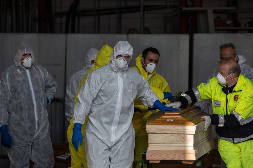 Carabinieri officers, wearing protective suits, transport coffins in Ponte San Pietro, near Bergamo, Northern Italy. The country has seen a higher number of deaths from the virus than anywhere else in the world. 