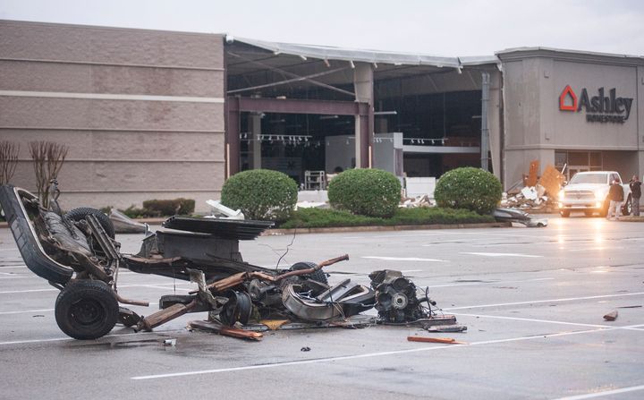 The damaged remains of a vehicle lie in a parking lot in front of a damaged Ashley Homestore after a tornado stuck Saturday, March 28, 2020, in Jonesboro, Ark. (Quentin Winstine/The Jonesboro Sun via AP)