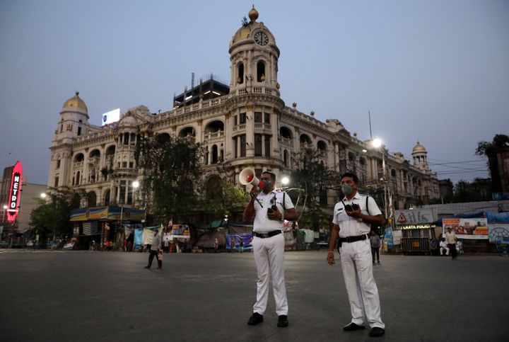 A police officer uses a megaphone advising people to vacate the roads after the lockdown by West Bengal governmen, in Kolkata, March 23, 2020. 