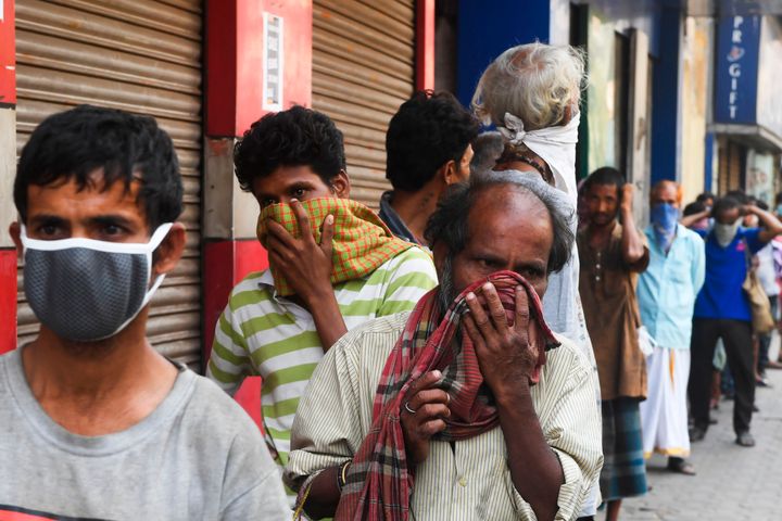 Daily-wage workers and the homeless queue up to get free food during a government-imposed nationwide lockdown as a preventive measure against the COVID-19 coronavirus in Kolkata on March 28, 2020. 