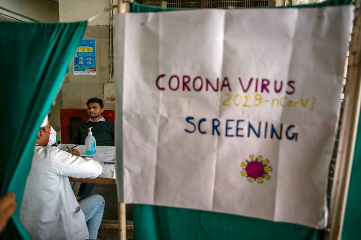 A doctor examines a patient in an area set aside for possible coronavirus cases during a free screening camp at a government hospital on March 16, 2020 in New Delhi