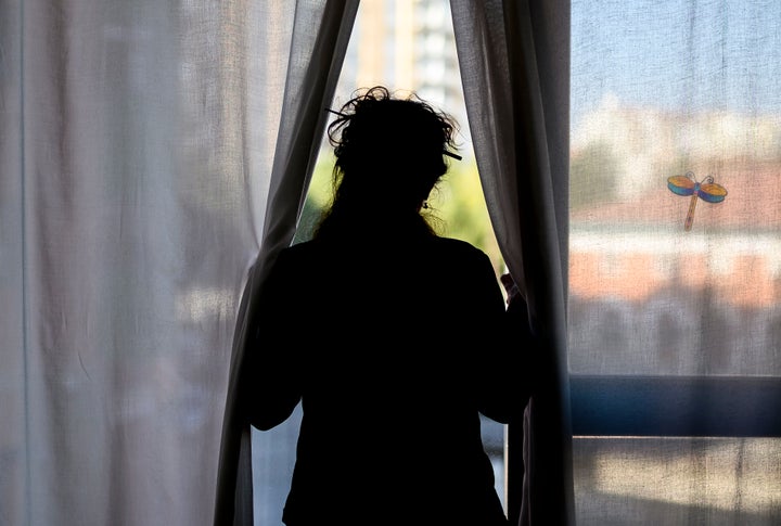 Una mujer mira por la ventana en Burgos durante el confinamiento.