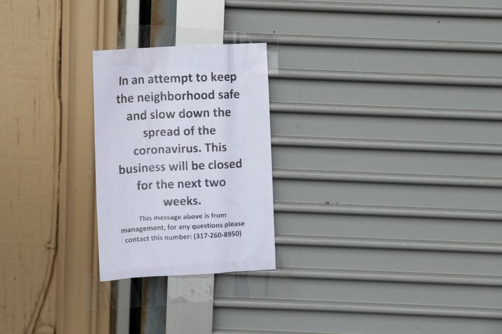 A sign on an Indianapolis liquor store announces its closure due to the coronavirus on March 28, 2020.