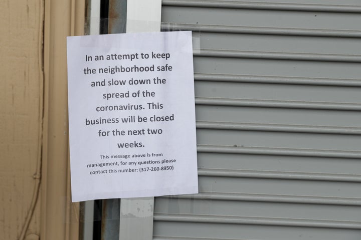 A sign on an Indianapolis liquor store announces its closure due to the coronavirus on March 28, 2020. 