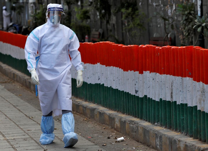 A health worker wearing a protective suit walks after moving people to a quarantine facility, amid concerns about the spread of coronavirus disease (COVID-19), in Nizamuddin area of New Delhi, India, March 30, 2020. REUTERS/Danish Siddiqui