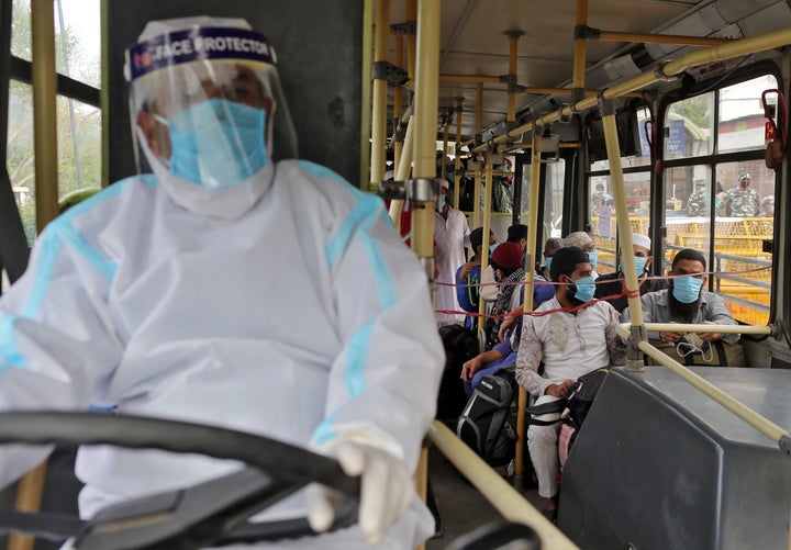 Men wearing protective masks sit inside a bus that will take them to a quarantine facility, amid concerns about the spread of coronavirus disease (COVID-19), in Nizamuddin area of New Delhi, India, March 30, 2020. 