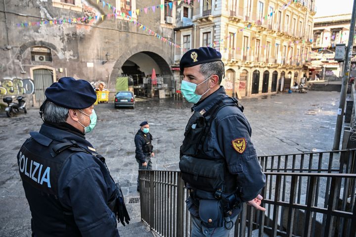Police with the protective masks control the traditional open-air fish market closed due to the coronavirus emergency on March 12 in Catania, Italy.