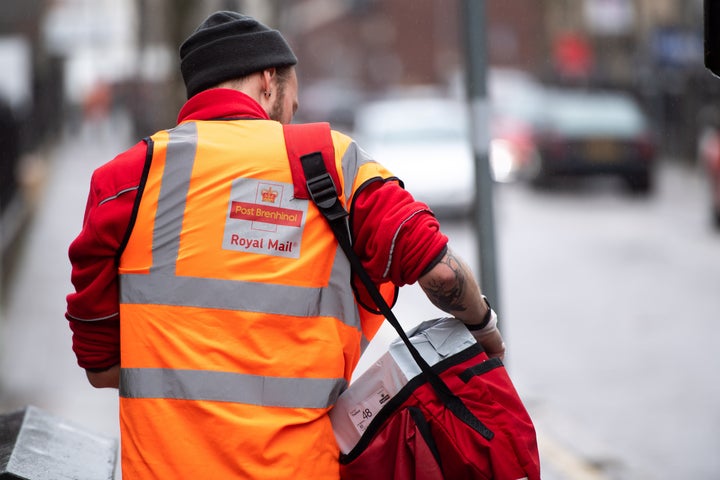 A postal worker delivers post on March 17, 2020 in Cardiff.