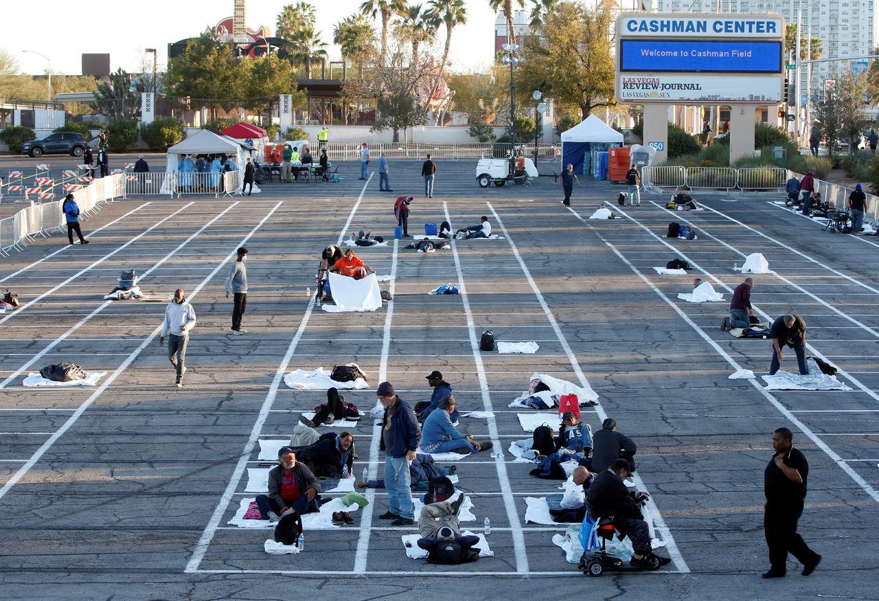 Homeless people get settled in a temporary parking lot shelter at Cashman Center, with spaces marked for social distancing to help slow the spread of coronavirus disease in Las Vegas.