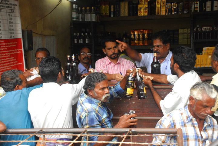 Customers buying alcohol from a shop run by Kerala State Beverages Corporation (KSBC) on Onam Day in Kerala.
