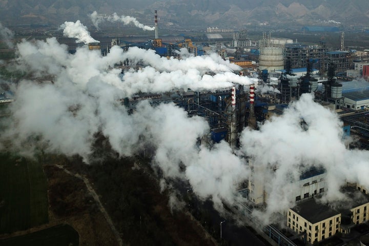 Smoke and steam rise from a coal processing plant that produces carbon black, an ingredient in steel manufacturing, in Hejin, China.