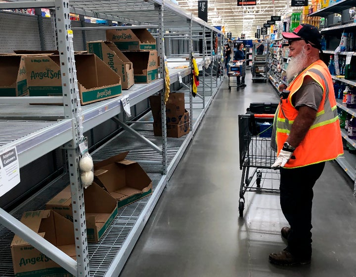 A shopper looks at a cleaned-out toilet paper aisle in a Phoenix Walmart, March 20.