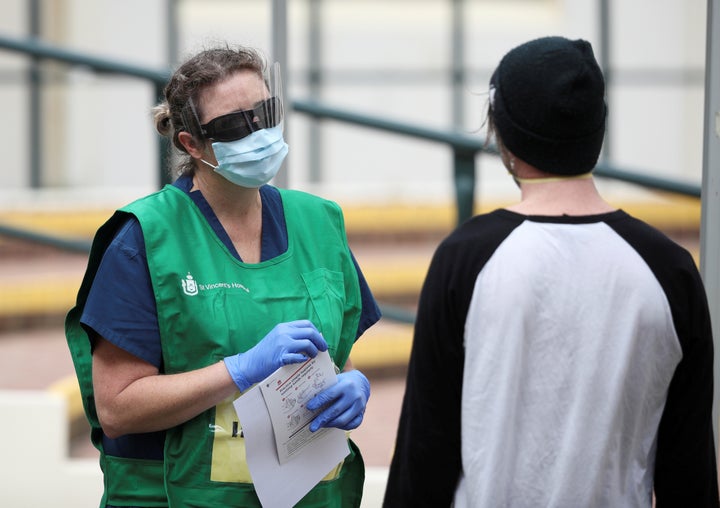 A healthcare professional talks to a man at a pop-up clinic testing for the coronavirus disease (COVID-19) at Bondi Beach, after several outbreaks were recorded in the area, in Sydney, Australia April 1, 2020. 